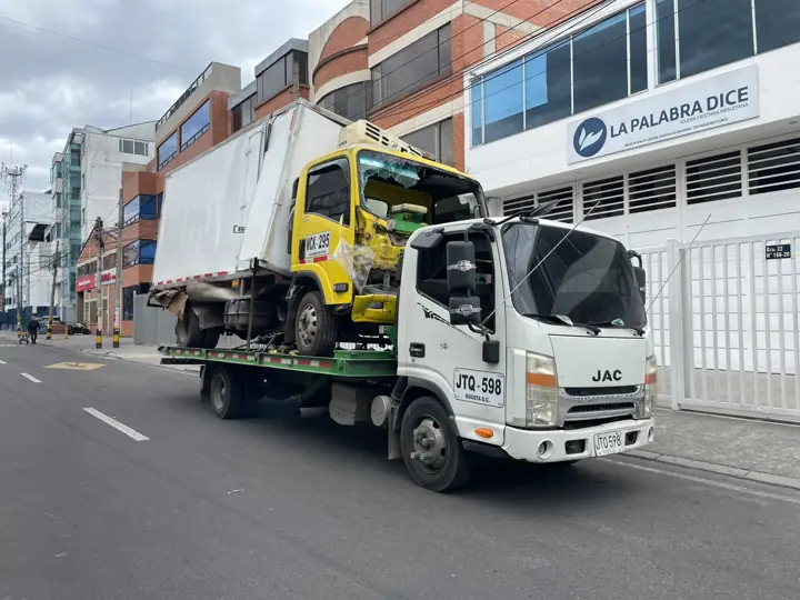 Grúa con camión amarillo en la ciudad
