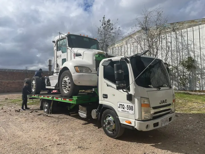 Grúa remolcando un camión blanco