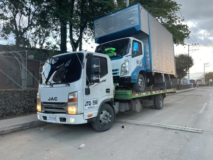 Grúa transportando un camión furgón