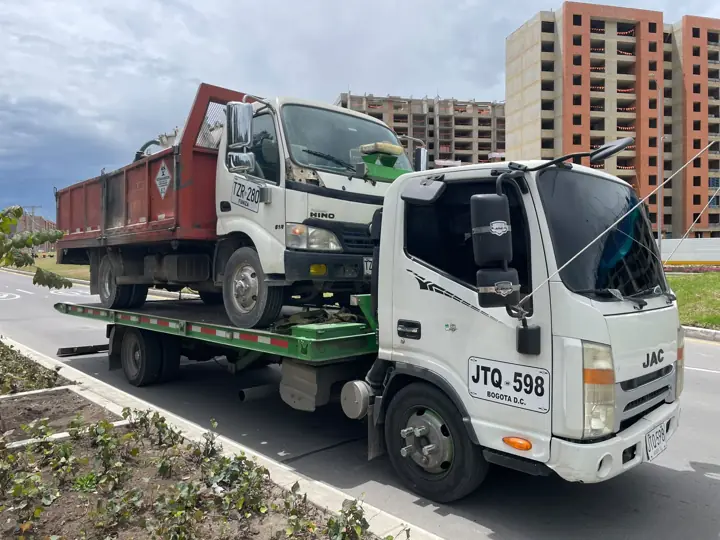 Grúa cargando un camión volqueta