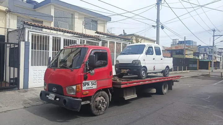 Grúa roja transportando un vehículo