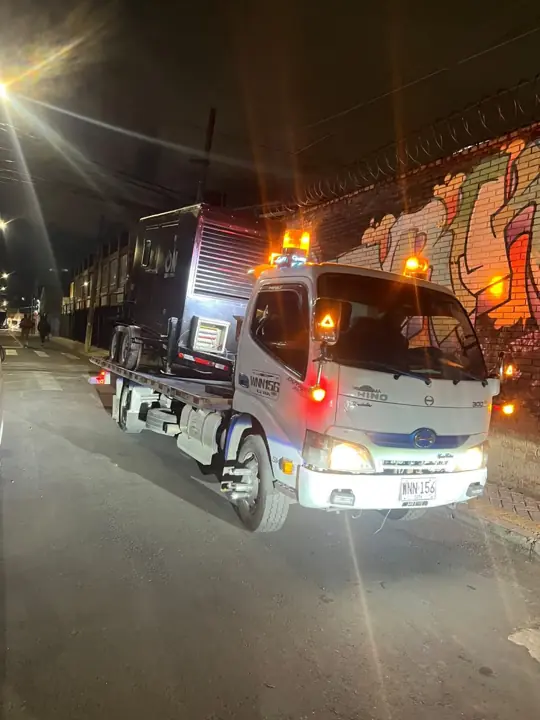 Grúa con luces de emergencia en la noche